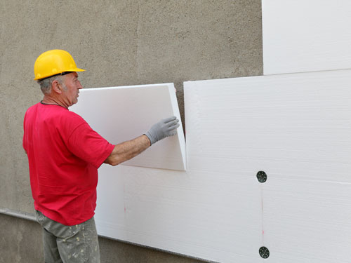 Worker installing SuperForm EIFS insulation panels